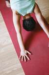personne yoga tapis rouge plancher bois clair