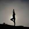 silhouette yoga au lever du soleil sur rochers