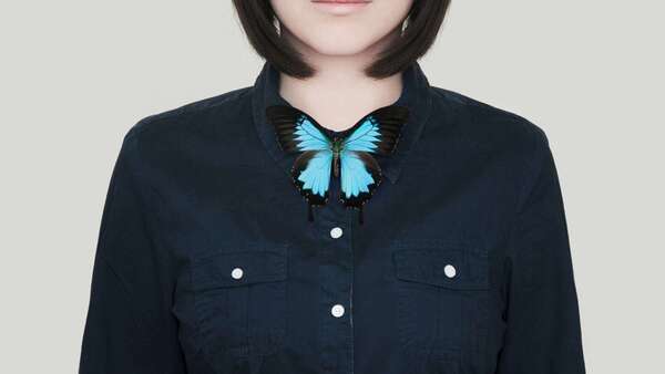 Femme avec un papillon bleu à la thyroïde, symbolisant l'équilibre thyroïdien