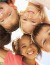 Enfants souriants formant cercle ciel bleu clair
