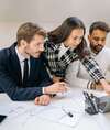 Quatre personnes en réunion collaborent sur des accompagnements confidentiels en milieu professionnel