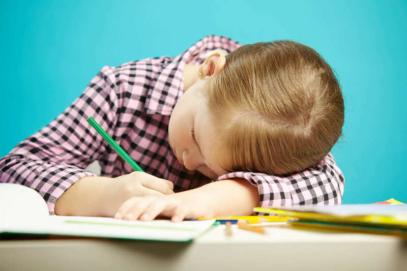 petite_fille_ecrivant_couchee_sur_son_bras