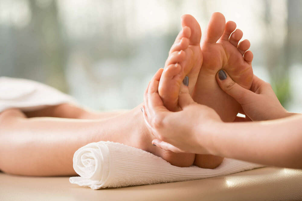 Séance de réflexologie plantaire, pieds détendus sur une serviette