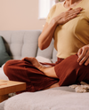 Femme assise, une main sur le coeur symbolisant la détente, la respiration, l'écoute intérieur en sophrologie.ente et la respiration en sophrologie.