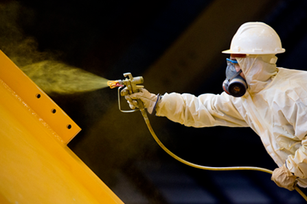 ouvrier appliquant peinture chimique