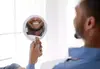 Homme souriant montrant ses dents brillantes en miroir