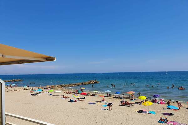 Plage de sable fin en été, vue depuis une terrasse