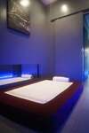Salle de massage asiatique à l'éclairage bleu avec matelas et serviettes