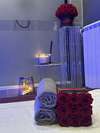 Cabine de massage avec serviettes roulées, bougies et encens