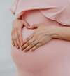Femme enceinte formant un cœur avec ses mains sur ventre