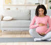 Femme enceinte souriante assise en tailleur yoga détente et bien-être