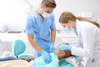 Dentiste et assistante expliquent options traitement enfant en clinique