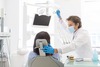 Dentiste ajustant lampe dentaire pour options traitement patient