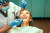 Dentiste réévaluant cicatrisation gencives patiente avec appareil dentaire