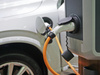 Véhicule électrique blanc en charge sur borne domestique sécurisée