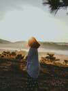 "Femme contemplant un paysage brumeux au lever du soleil, symbole de sérénité et d'affirmation de soi".