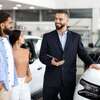 vendeur automobile souriant présente voiture blanche showroom