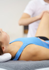 Physiothérapeute examinant le bas du dos pour troubles du cycle