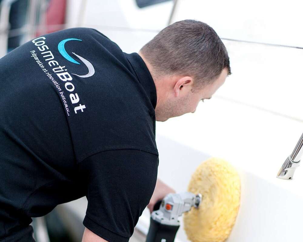 Technicien CosmétiBoat passe polisseuse sur coque bateau