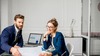 Deux personnes analysant graphiques boursiers en bureau moderne