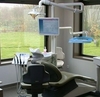 Fauteuil dentaire et écran dans une salle de soins éclairée