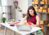 Une jeune femme concentrée, assise devant son ordinateur, en plein processus de copywriting pour optimiser le contenu d'un site web.