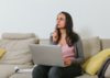 Une femme concentrée naviguant sur son ordinateur, recherchant des informations sur le copywriting.