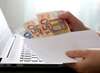 billets euros enveloppe sur ordinateur portant entretien chauffe-eau