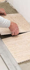 Pose de carreaux beige par un carreleur illustrant l entretien et les prestations de carrelage