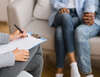 psychologue prenant des notes avec un couple en thérapie