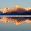 Montagnes enneigées reflétant calme lac sous soleil levant