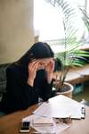 Femme stressée assise à table avec documents gestion du stress