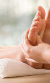 Massage des pieds en séance de réflexologie plantaire apaisante