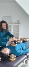 Femme utilisant bols tibétains pour relaxation sonore vibratoire
