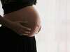 Femme enceinte écoutant son ventre attentivement