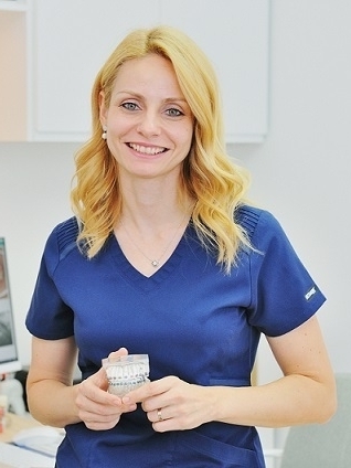 Orthodontiste à Aix-en-Provence, Dr Andreea Gociu tenant un modèle dentaire pédagogique