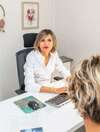 Femme en consultation professionnelle devant ordinateur au bureau