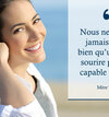 Femme souriante devant mur briques avec prothèse amovible
