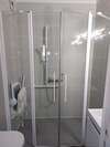 salle de bain accessible avec douche sécurisée et barres d'appui