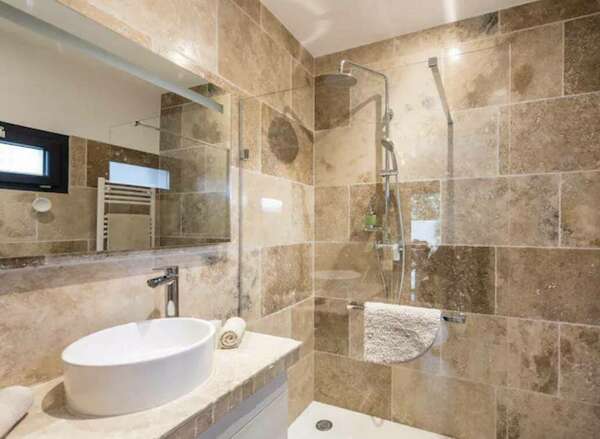 On voit une faïence de type travertain sur les parois d'une salle de bain