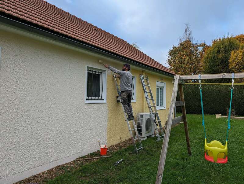 façade de maison qui est en train d'être nettoyé par un artisan