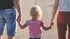 enfant tenant la main de ses parents