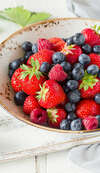 fruits rouges frais disposés sur une assiette en bois blanc