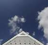 Toit de maison clair sous un ciel bleu avec fissures visibles