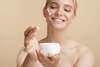 femme blonde qui met de la crème sur son visage