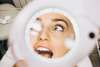 Visage féminin à travers la loupe dans un salon de beauté