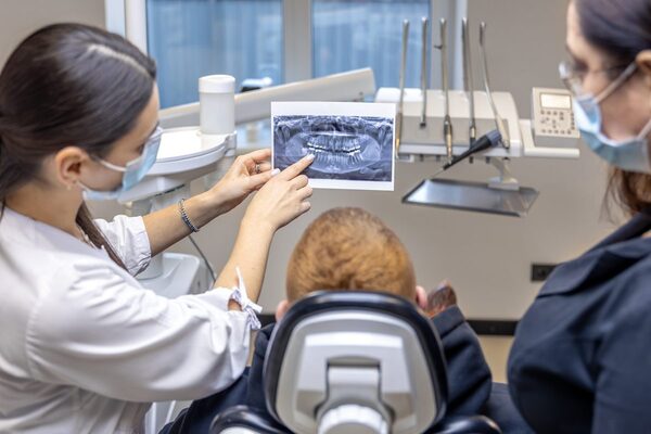 Dentiste présentant une radiographie panoramique à une patiente