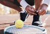 Athlete de tennis refaisant son lacet