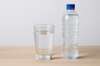 Verre d’eau et bouteille posés sur une table pour illustrer l’importance de l’hydratation