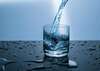 Verre d’eau posé sur une table en bois pour rappeler l’importance de l’hydratation